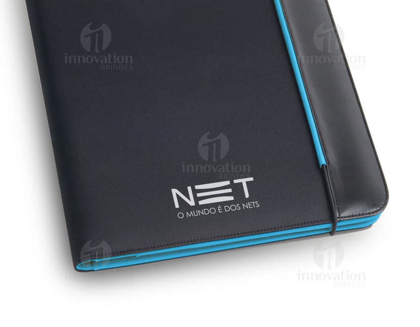 Pasta A4 - 09 em couro preto, com espaço para notebook, dispositivos, drive externo, documentos, pen drive, informações, escrita, planejamento e armazenamento. Design moderno e compacto, ideal para ambiente de escritório e negócios.