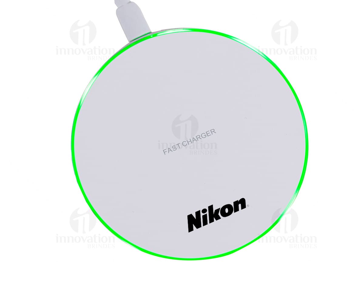 Carregador por indução redondo para desktop com design moderno e acabamento metálico. Ideal para manter seus dispositivos sempre carregados com praticidade. A tecnologia de indução elimina a necessidade de cabos, tornando o processo mais simples e eficiente. A imagem ilustrativa destaca a praticidade e elegância do produto, com reflexo e sombra levemente inclinados. Não perca tempo e adquira já o seu carregador por indução para manter seus aparelhos sempre carregados. Ideal para uso empresarial e pessoal. Confira já!