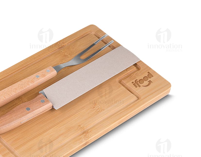 Kit churrasco composto por 3 peças (faca, garfo e espátula) e uma tábua de madeira.