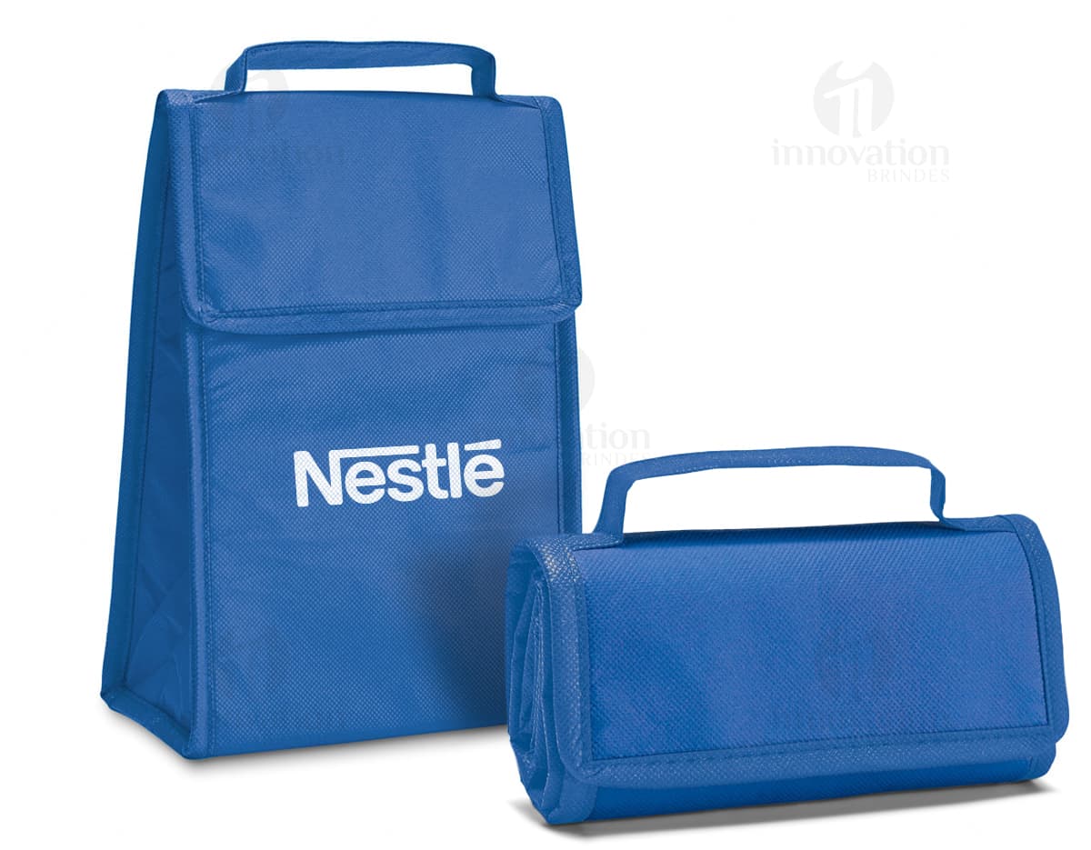 Bolsa térmica dobrável em formato 3D, vazia e aberta, com design moderno e clean. Está sobre uma mesa ao lado de um computador, um notebook e um dispenser de sabonete. A imagem contém elementos como embalagem de plástico, papel em branco, ícones de tecnologia e etiquetas de informação.