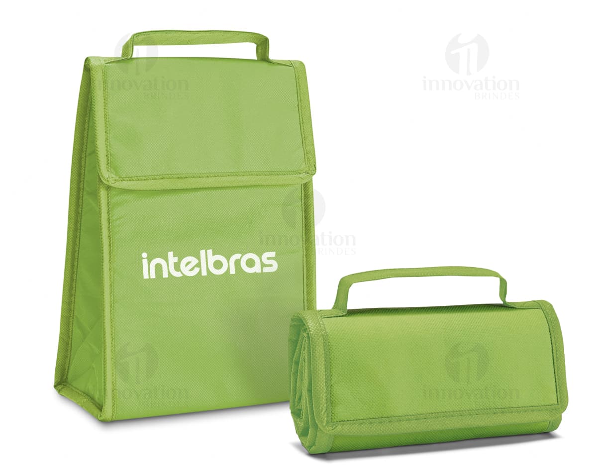 Bolsa térmica dobrável em formato 3D, vazia e aberta, com design moderno e clean. Está sobre uma mesa ao lado de um computador, um notebook e um dispenser de sabonete. A imagem contém elementos como embalagem de plástico, papel em branco, ícones de tecnologia e etiquetas de informação.