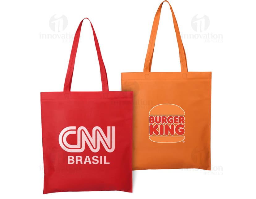 Sacola de compras de tecido não tecido (TNT) de 100g com alça de 60cm. A sacola é amarela e possui um design moderno e colorido. Está vazia e pronta para ser usada para transportar mercadorias. A embalagem é resistente e possui alças fortes para carregar. Ideal para compras, presentes e uso diário.