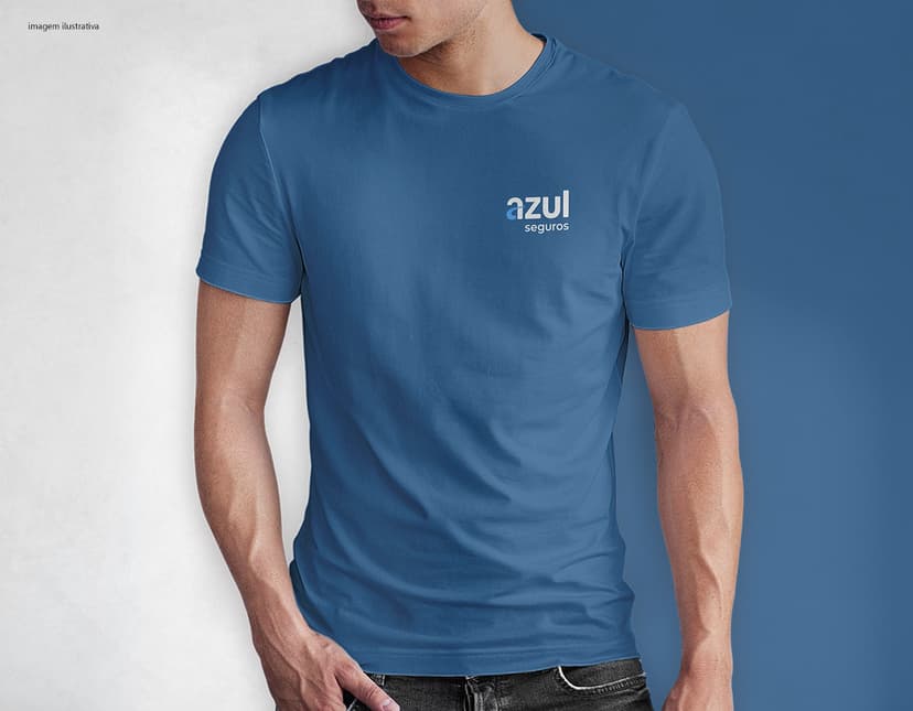 Homem jovem e atraente sorrindo, posando em um estúdio com uma camiseta preta de algodão tradicional de 165g/m². Ele está vestindo jeans, tem cabelo escuro e expressão feliz. O modelo está em pé, com um sorriso confiante, e possui uma aparência moderna e masculina.