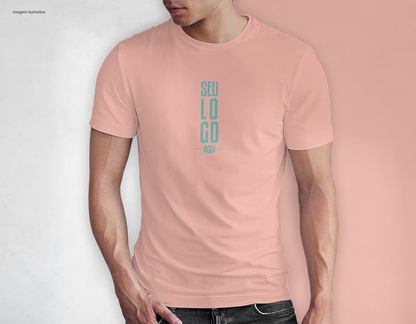 Homem jovem e atraente sorrindo, posando em um estúdio com uma camiseta preta de algodão tradicional de 165g/m². Ele está vestindo jeans, tem cabelo escuro e expressão feliz. O modelo está em pé, com um sorriso confiante, e possui uma aparência moderna e masculina.