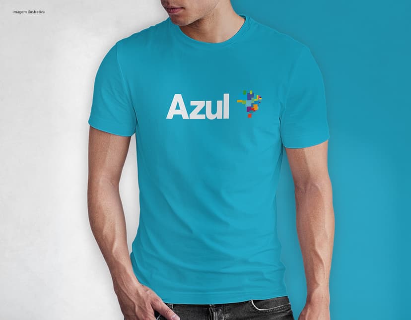 Homem jovem e atraente sorrindo, posando em um estúdio com uma camiseta preta de algodão tradicional de 165g/m². Ele está vestindo jeans, tem cabelo escuro e expressão feliz. O modelo está em pé, com um sorriso confiante, e possui uma aparência moderna e masculina.