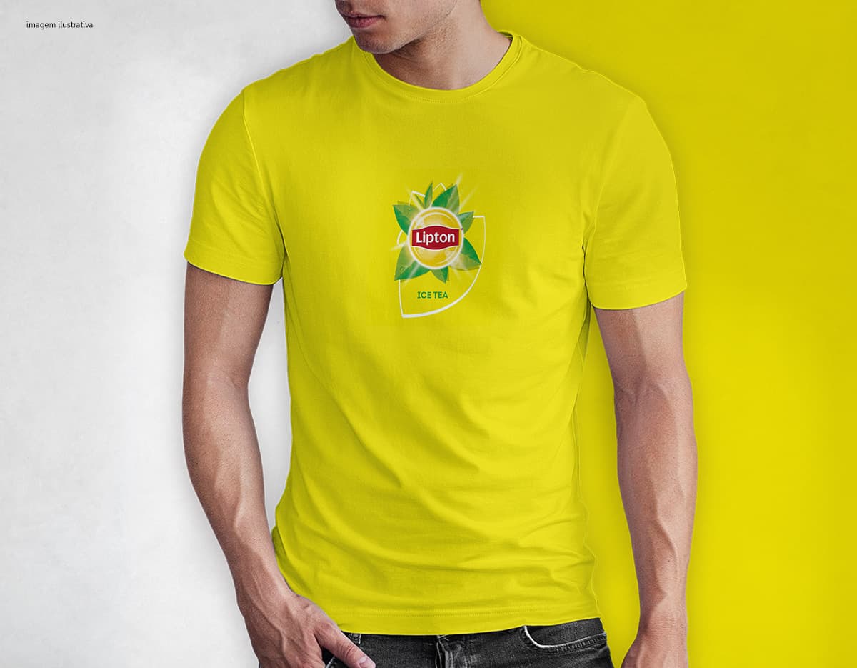 Homem jovem e atraente sorrindo, posando em um estúdio com uma camiseta preta de algodão tradicional de 165g/m². Ele está vestindo jeans, tem cabelo escuro e expressão feliz. O modelo está em pé, com um sorriso confiante, e possui uma aparência moderna e masculina.