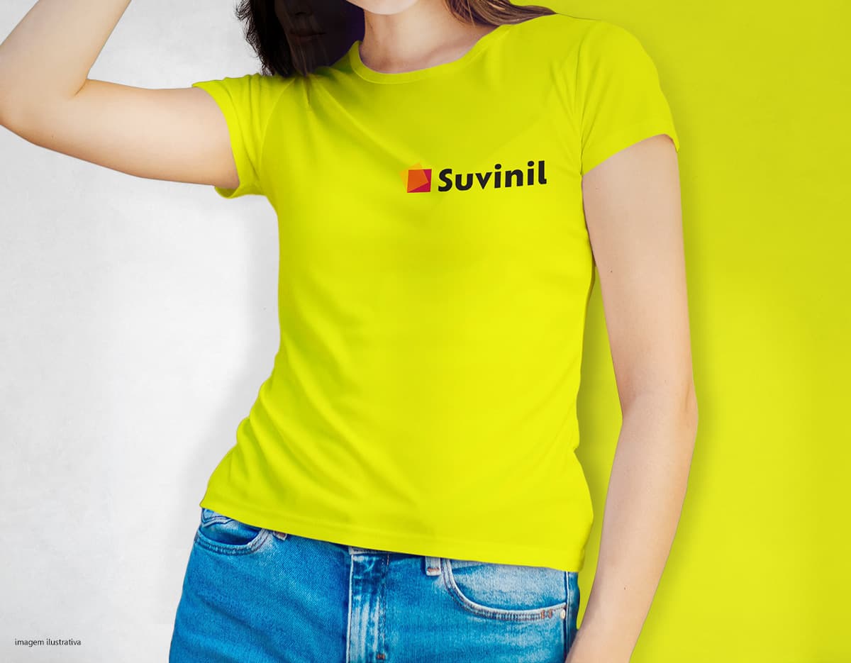 Camiseta feminina de corte cinturado em cor azul, usada por uma modelo sorridente e atraente. Ela está posando de forma casual e elegante, com cabelo escuro e jeans. A roupa é moderna e estilosa, perfeita para mulheres jovens e modernas.