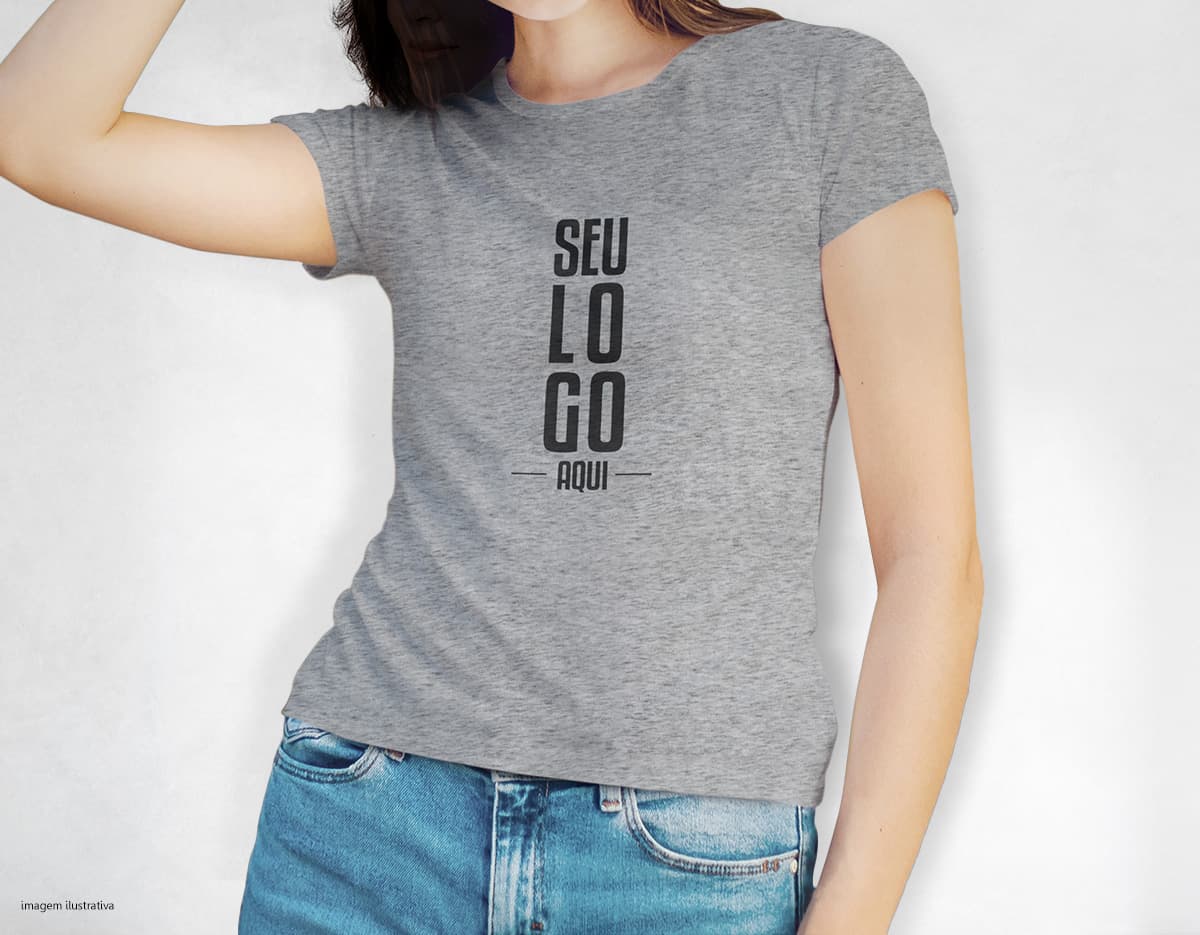 Camiseta feminina de corte cinturado em cor azul, usada por uma modelo sorridente e atraente. Ela está posando de forma casual e elegante, com cabelo escuro e jeans. A roupa é moderna e estilosa, perfeita para mulheres jovens e modernas.