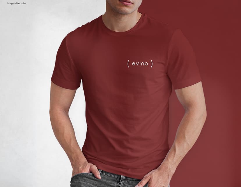 Homem jovem e atraente posando de maneira casual com uma camiseta de algodão tradicional. Ele está sorrindo e tem um sorriso feliz e confiante. O modelo está vestindo jeans e tem um visual moderno e descontraído.