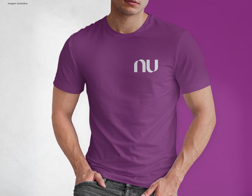 Homem jovem e atraente posando de maneira casual com uma camiseta de algodão tradicional. Ele está sorrindo e tem um sorriso feliz e confiante. O modelo está vestindo jeans e tem um visual moderno e descontraído.