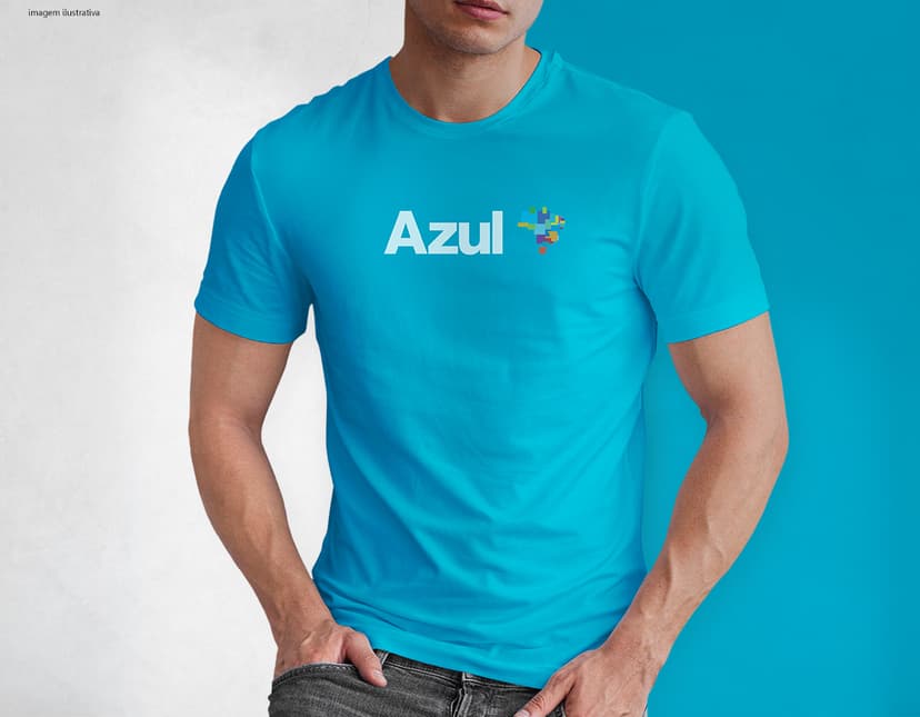 Homem jovem e atraente posando de maneira casual com uma camiseta de algodão tradicional. Ele está sorrindo e tem um sorriso feliz e confiante. O modelo está vestindo jeans e tem um visual moderno e descontraído.