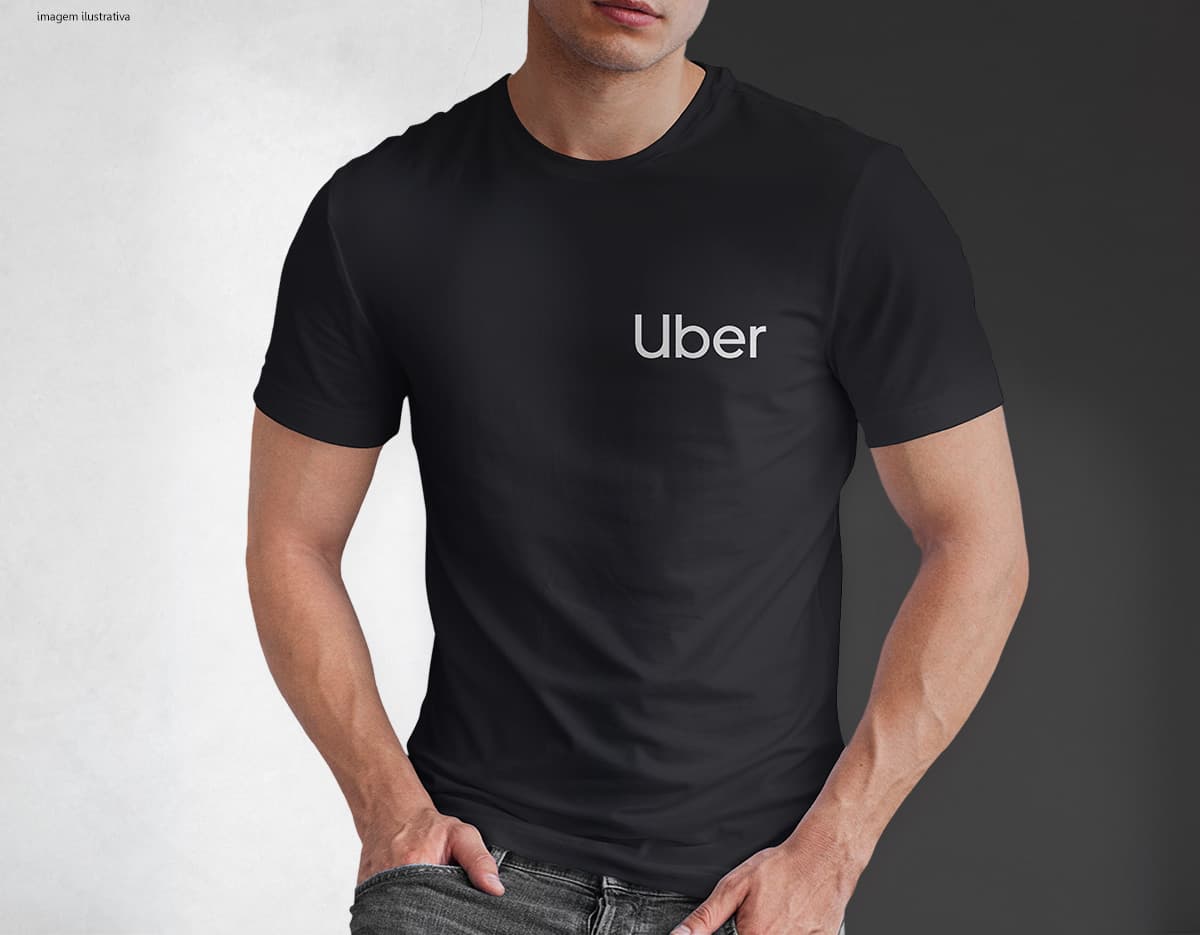 Homem jovem e atraente posando de maneira casual com uma camiseta de algodão tradicional. Ele está sorrindo e tem um sorriso feliz e confiante. O modelo está vestindo jeans e tem um visual moderno e descontraído.