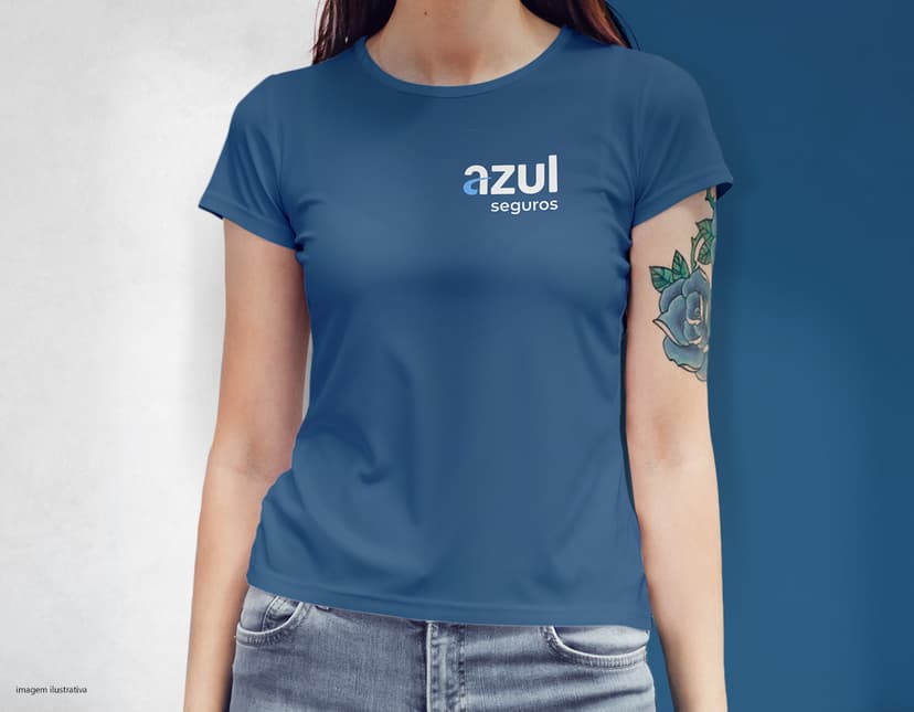 Camiseta feminina com uma garota atraente e sorridente, posando de forma casual em um estúdio. O modelo tem cabelos escuros e olhos expressivos, vestindo jeans. Ela transmite confiança e estilo.