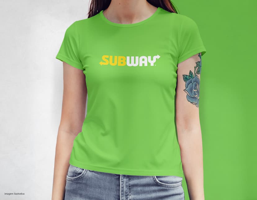 Camiseta feminina com uma garota atraente e sorridente, posando de forma casual em um estúdio. O modelo tem cabelos escuros e olhos expressivos, vestindo jeans. Ela transmite confiança e estilo.