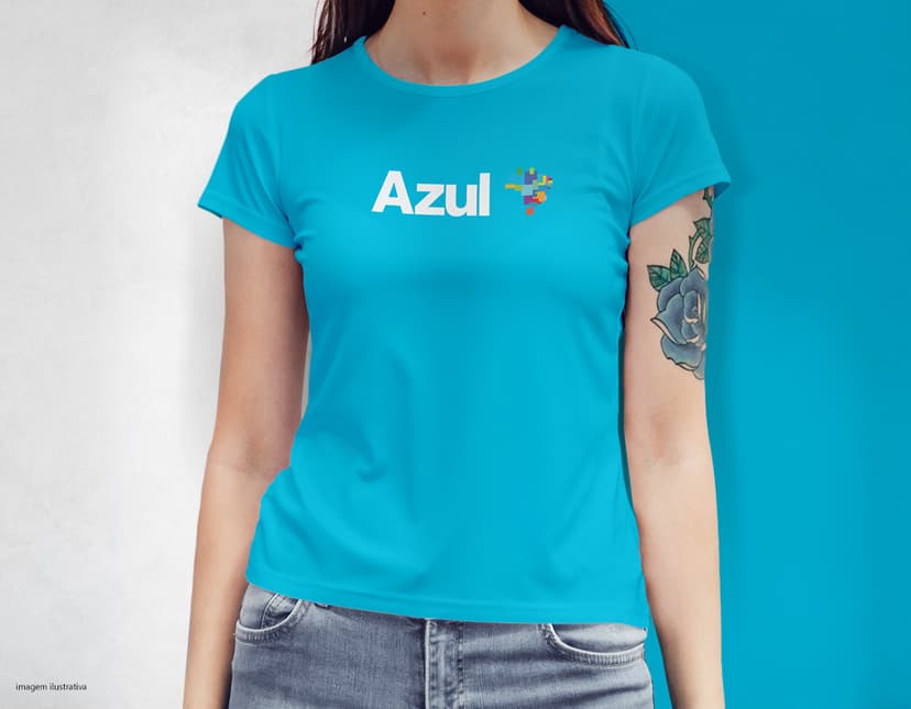 Camiseta feminina com uma garota atraente e sorridente, posando de forma casual em um estúdio. O modelo tem cabelos escuros e olhos expressivos, vestindo jeans. Ela transmite confiança e estilo.