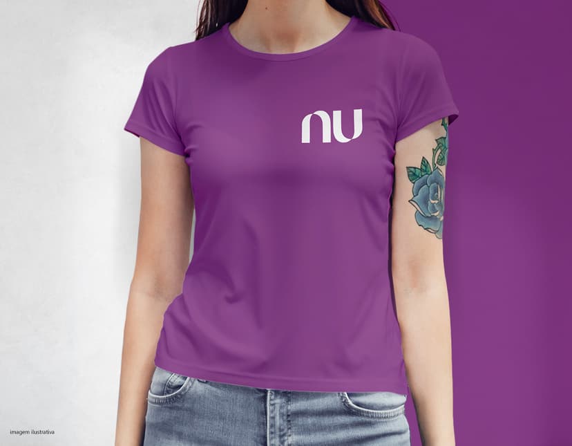 Camiseta feminina com uma garota atraente e sorridente, posando de forma casual em um estúdio. O modelo tem cabelos escuros e olhos expressivos, vestindo jeans. Ela transmite confiança e estilo.