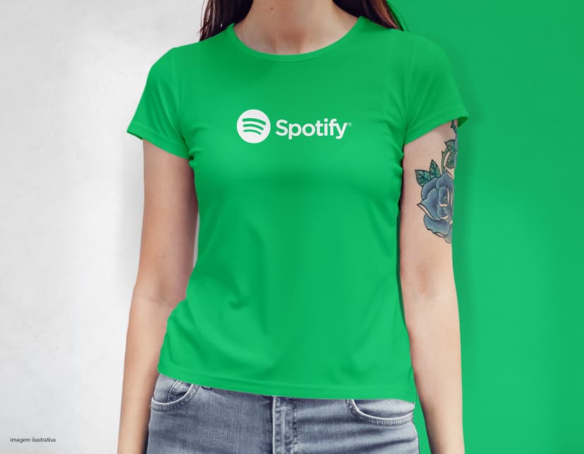 Camiseta feminina com uma garota atraente e sorridente, posando de forma casual em um estúdio. O modelo tem cabelos escuros e olhos expressivos, vestindo jeans. Ela transmite confiança e estilo.