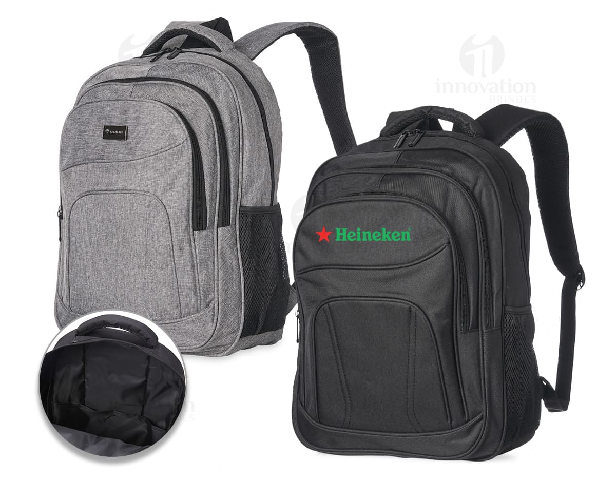 Homem sorrindo, vestindo terno, carregando uma mochila de nylon preta de 30 litros nas costas.