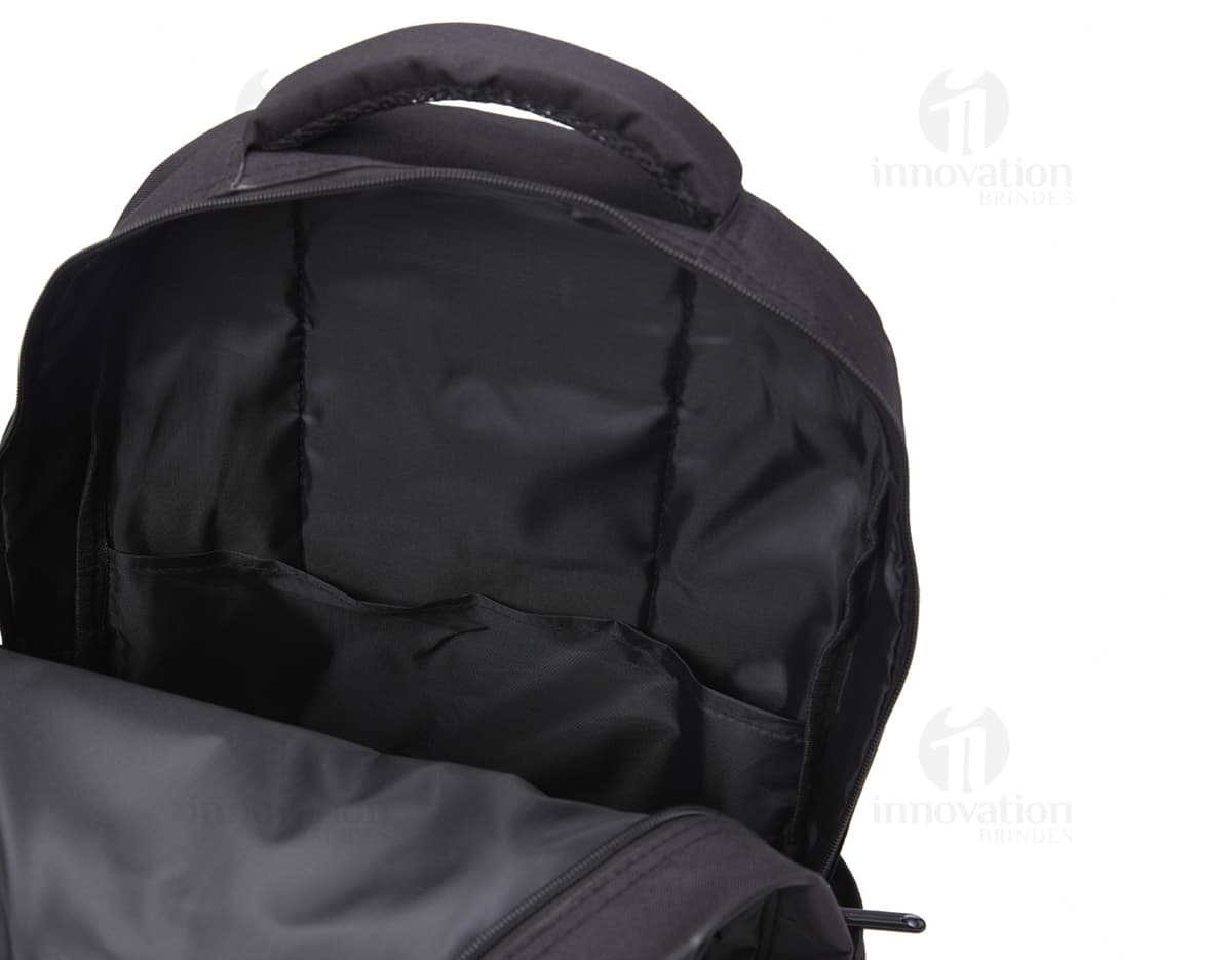 Homem sorrindo, vestindo terno, carregando uma mochila de nylon preta de 30 litros nas costas.