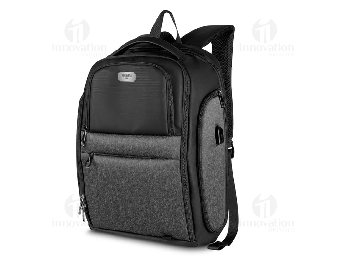 Mochila Premium para notebook com USB, possui fecho de metal, bolso em jeans, detalhes em couro, design vintage e botão de pressionar.
