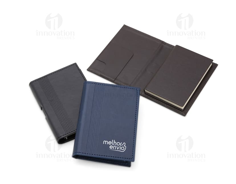 Bloco de anotações com porta caneta em um escritório vazio. O caderno está aberto em uma página em branco e ao lado há um videodisco. O design é moderno e conta com um espaço para guardar objetos, como canetas. O ambiente é limpo e organizado, com um ar de nostalgia.