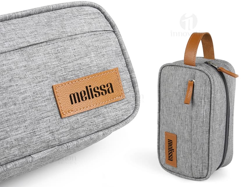 Necessaire de poliéster com detalhes em couro sintético, moderna e elegante. Compartimento único, fecho de correr, estilo casual e acessório de luxo para guardar itens de forma organizada.