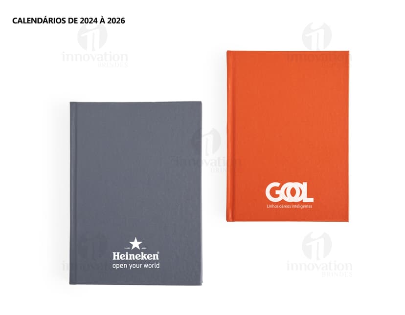 Agenda 2025 Cromato com capa em amarelo, vazio, na mesa de escritório com notebook, papel em branco, livro aberto e envelope.