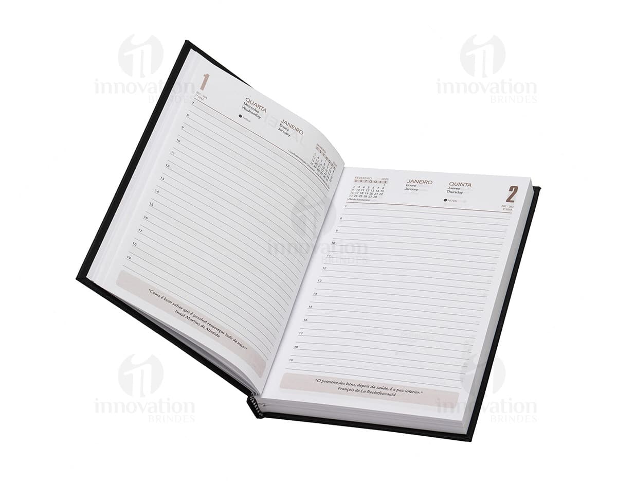 Agenda 2025 Cromato com capa dura na cor prateada e detalhes em relevo. Páginas internas contendo calendários e espaços para anotações.