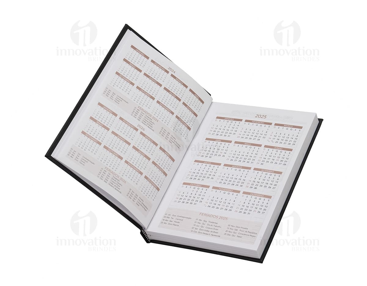 Agenda 2025 Cromato com capa dura na cor prateada e detalhes em relevo. Páginas internas contendo calendários e espaços para anotações.