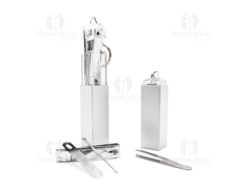 Chaveiro Kit Manicure 4 peças em formato de dispositivo moderno, feito em aço cromado e preto. Possui ferramentas de manicure práticas e funcionais, como cortador de unhas, lixa, pinça e empurrador de cutícula. Ideal para ser usado em casa, no escritório ou durante viagens. Embalagem minimalista e elegante, perfeita para presentear.