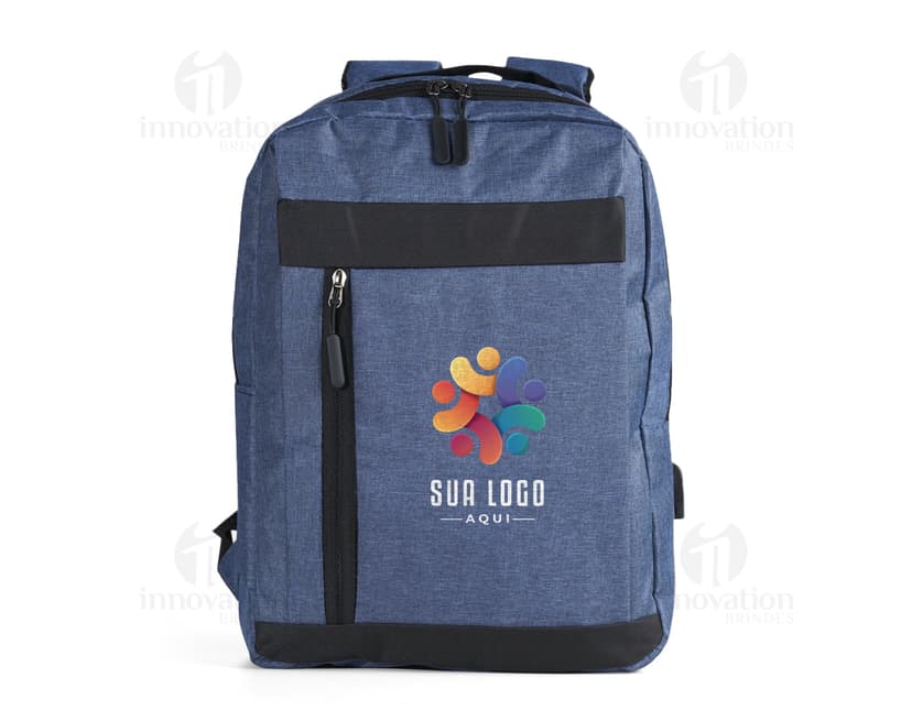 Homem de negócios usando um dispositivo eletrônico em um avião, com uma mochila de nylon preta nas costas. O bolso da mochila contém um cabo USB e há um jeans preto amarrado ao redor da alça.