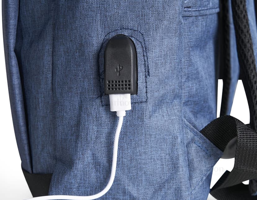 Homem de negócios usando um dispositivo eletrônico em um avião, com uma mochila de nylon preta nas costas. O bolso da mochila contém um cabo USB e há um jeans preto amarrado ao redor da alça.