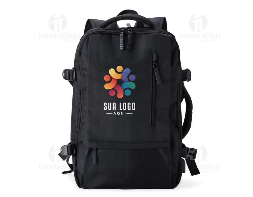 Homem de negócios usando um elegante terno preto, segurando uma mochila de nylon preta de 20 litros com USB. O acessório tem apoio nas costas, alça, e suporte para objetos.