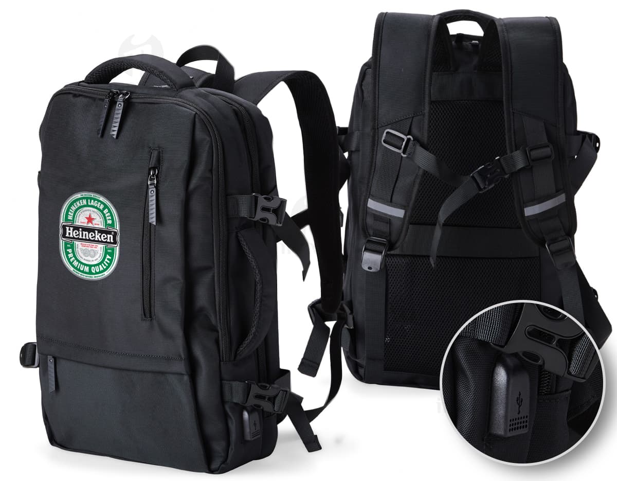Homem de negócios usando um elegante terno preto, segurando uma mochila de nylon preta de 20 litros com USB. O acessório tem apoio nas costas, alça, e suporte para objetos.