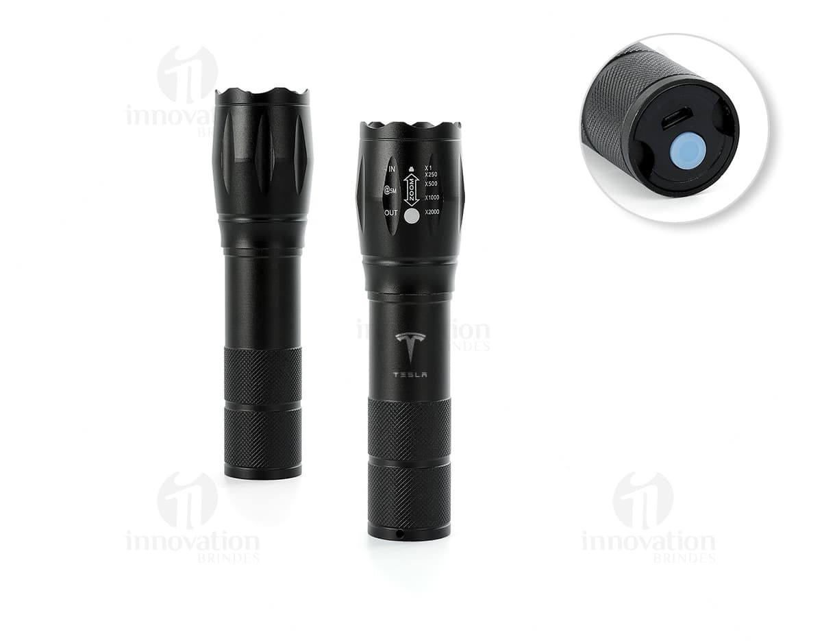 Lanterna led recarregável com zoom, em metal prateado e detalhes em plástico preto. O equipamento possui design clássico e elegante, ideal para uso em casa, escola ou no trabalho.