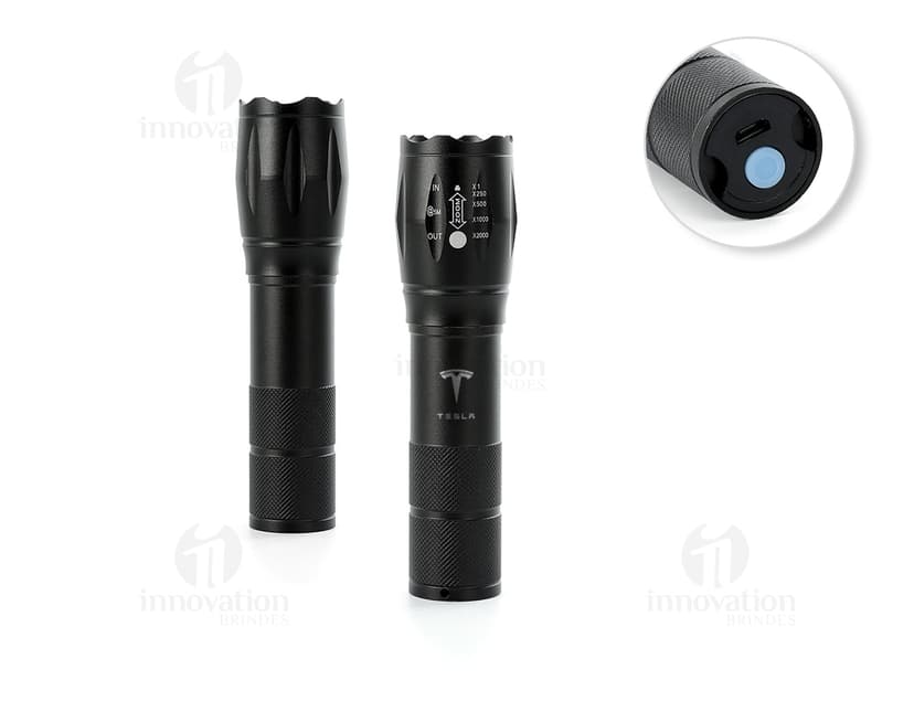 Lanterna led recarregável com zoom, em metal prateado e detalhes em plástico preto. O equipamento possui design clássico e elegante, ideal para uso em casa, escola ou no trabalho.