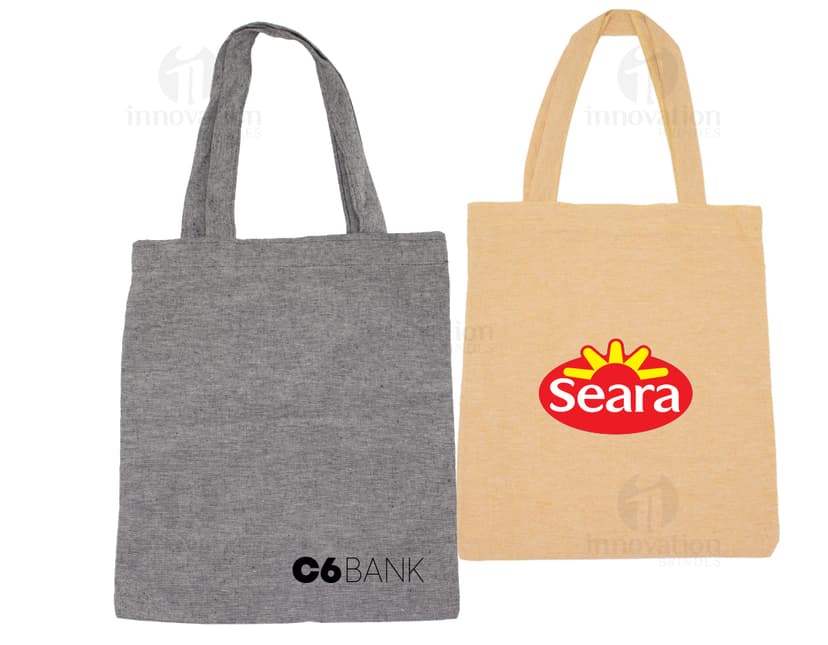 Sacolas de algodão marrom com alças internas em uma loja de moda feminina. Os sacos estão vazios e fechados com etiquetas de papel e fechos de segurança. O design inclui um símbolo de cadeado e etiquetas de preço. Ideal para embalar roupas, presentes ou mercadorias, proporcionando segurança e proteção aos itens contidos.