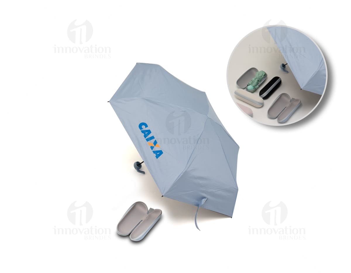 Guarda chuva manual sendo segurado por uma pessoa sorridente em um escritório moderno com um computador e monitor ao fundo. O guarda chuva é preto e está aberto, sugerindo proteção contra a chuva. A pessoa está vestindo roupas profissionais e parece feliz. A imagem transmite a ideia de segurança e conforto em dias chuvosos.