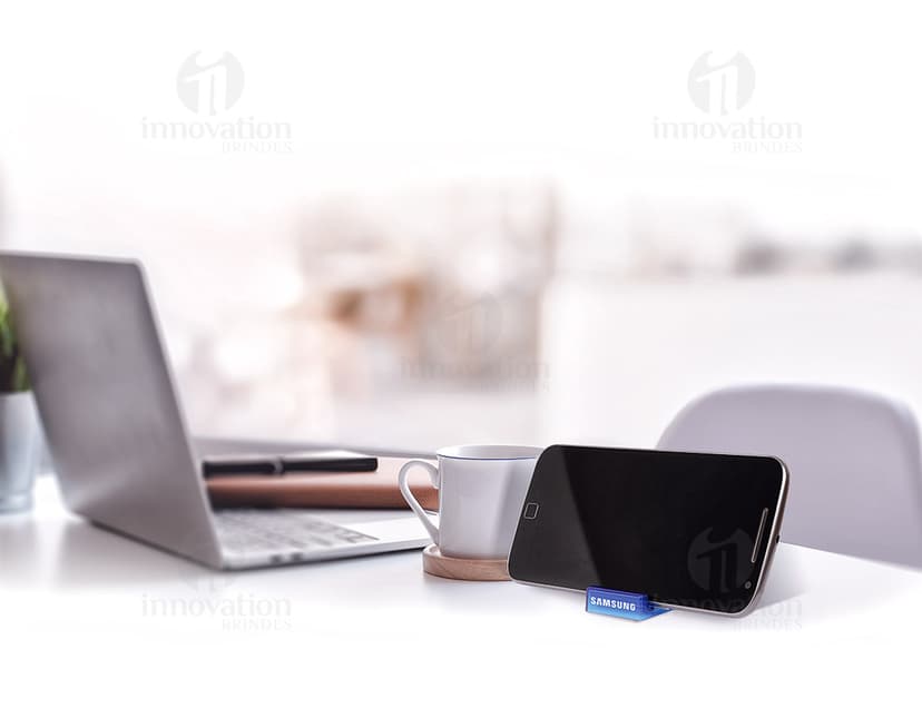 Suporte acrílico para celular em um escritório com computador, notebook, lápis, tela digital e outros equipamentos de escritório.