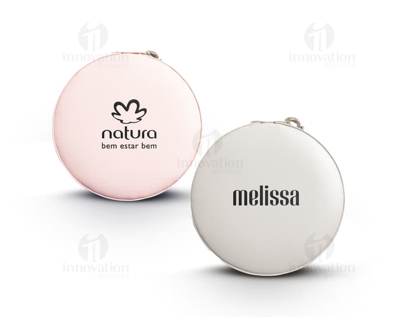Um porta jóia de metal prateado, com tampa de vidro circular e lente de aumento embutida. O objeto possui um design tecnológico e futurista, com acabamento brilhante e textura de alumínio.É um recipiente de armazenamento para jóias e acessórios, ideal para manter suas peças protegidas e organizadas.