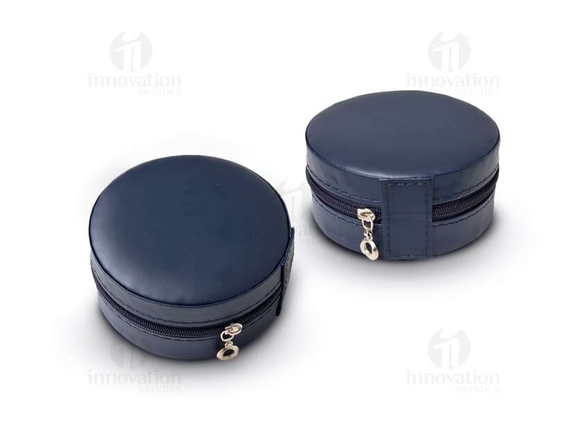 Um porta jóia de metal prateado, com tampa de vidro circular e lente de aumento embutida. O objeto possui um design tecnológico e futurista, com acabamento brilhante e textura de alumínio.É um recipiente de armazenamento para jóias e acessórios, ideal para manter suas peças protegidas e organizadas.