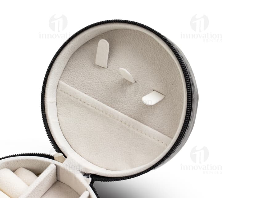 Um porta jóia de metal prateado, com tampa de vidro circular e lente de aumento embutida. O objeto possui um design tecnológico e futurista, com acabamento brilhante e textura de alumínio.É um recipiente de armazenamento para jóias e acessórios, ideal para manter suas peças protegidas e organizadas.