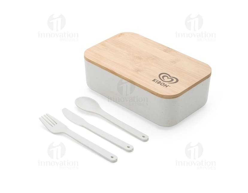 Marmita Fibra Trigo em uma imagem com utensílios de cozinha, comida, objetos metálicos, talheres, pratos vazios e reflexos brilhantes em uma mesa de restaurante.