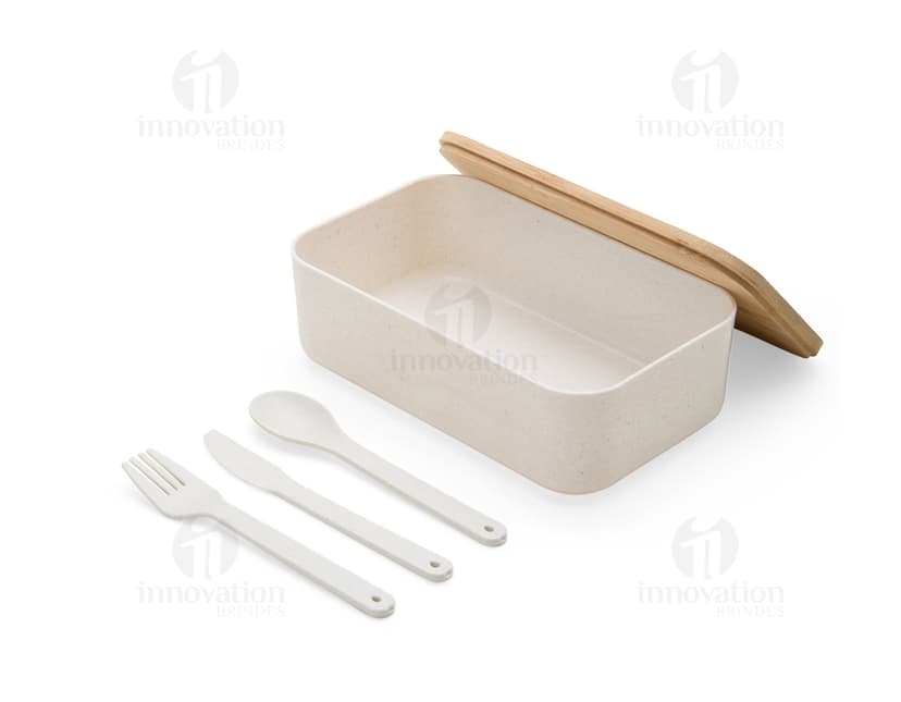 Marmita Fibra Trigo em uma imagem com utensílios de cozinha, comida, objetos metálicos, talheres, pratos vazios e reflexos brilhantes em uma mesa de restaurante.