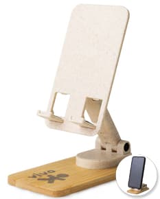 Suporte retrátil para celular 360° em papel marrom vazio, com textura antiga e desgastada. O suporte é amarelo com detalhes em madeira e metal, oferecendo um design vintage e grunge. O objeto está em cima de um bloco de madeira velho, em um espaço de escritório desorganizado.