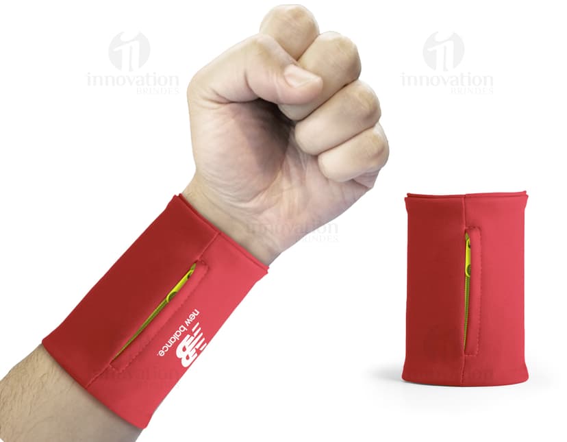 Homem de terno segurando um punho elástico com bolso zíper, mostrando um cartão de crédito.