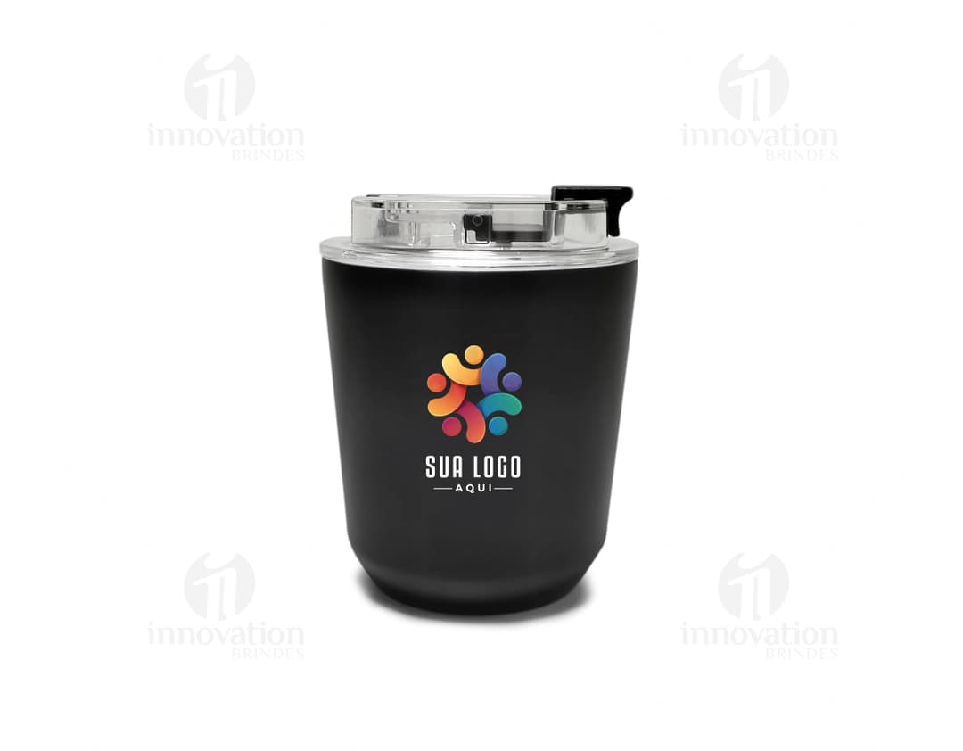 Copo térmico de 280ml em cerâmica preta e metal de cor prateada, com alça e tampa. O copo está vazio e posicionado sobre uma mesa de cozinha, ao lado de uma colher, uma jarra de café e alguns utensílios.