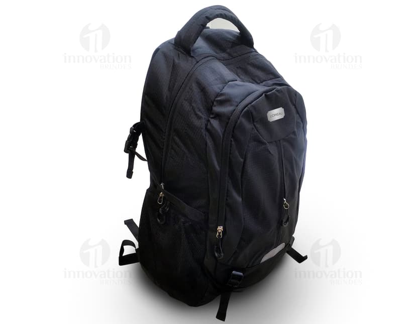 Homem usando mochila de nylon 43 litros em um estúdio. Ele está sorrindo e parece confiante, vestindo um terno preto e uma jaqueta de couro.