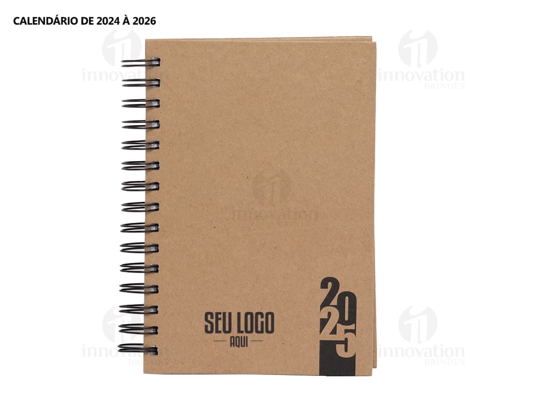 Foto de uma agenda diária para o ano de 2025, com capa marrom e textura de papel antigo. A agenda possui espiral, páginas em branco, listras amarelas e detalhes vintage. No fundo, um quadro antigo e desgastado complementa a composição.