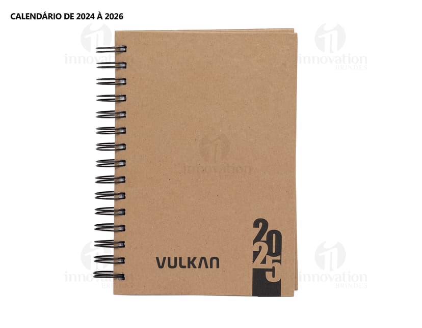 Foto de uma agenda diária para o ano de 2025, com capa marrom e textura de papel antigo. A agenda possui espiral, páginas em branco, listras amarelas e detalhes vintage. No fundo, um quadro antigo e desgastado complementa a composição.